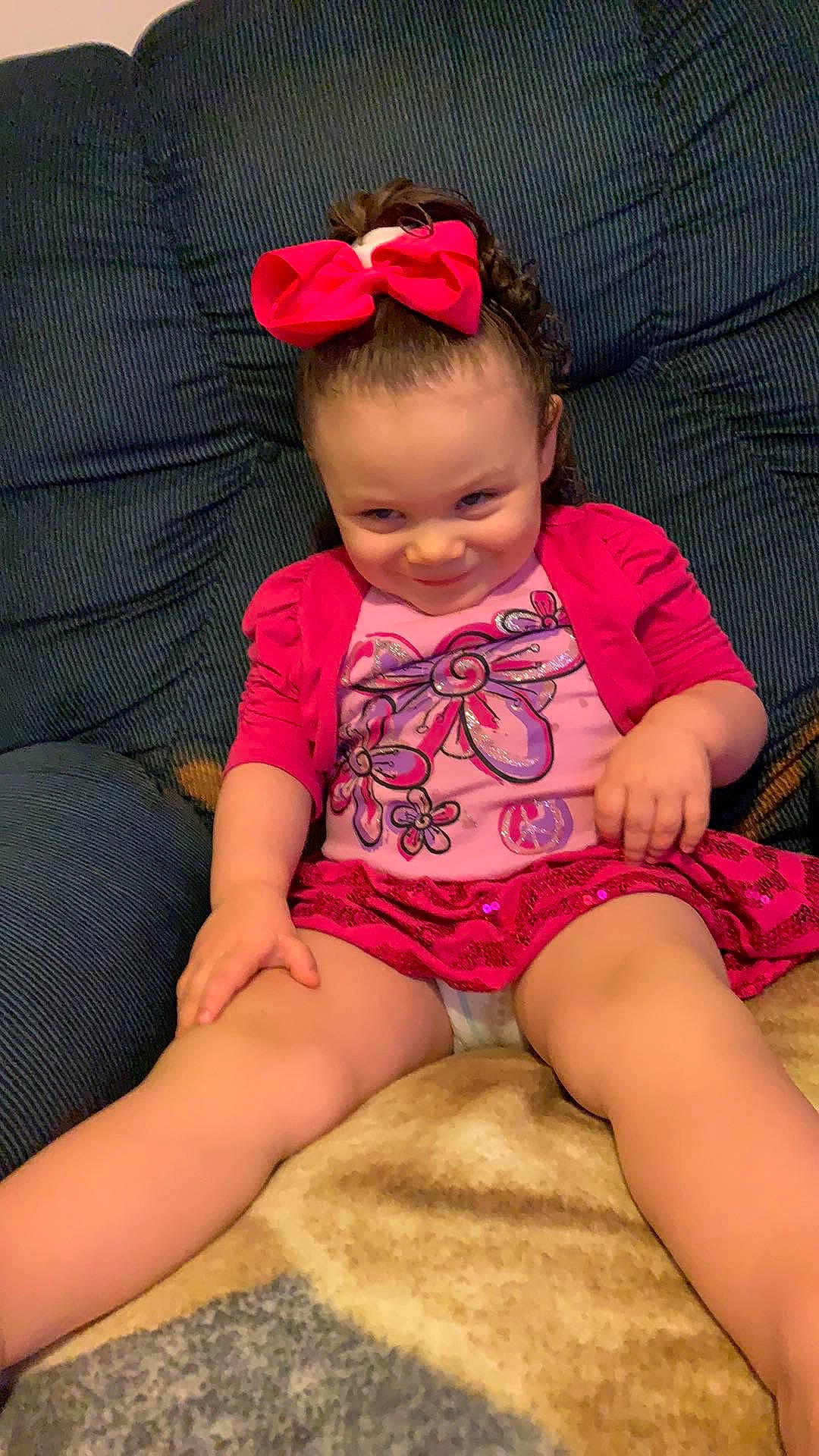 Emmalea is registered to the contest to win money with this photo: arm, baby, baby_toddler_clothing, cheek, child, finger, hair_accessory, human_leg, joy, leg, magenta, person, pink, play, sitting, skin, thigh, thumb, toddler