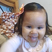 Mariana joined the competition — help win amazing prizes! toddler, child, baby, smiling, tongue_out, pink_bow, long_hair, bedroom, blanket, wooden_headboard, pajamas, indoors, cute, happy, portrait, young_child, person, playful, fun, close_up