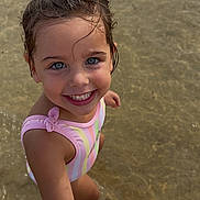 Juliana a rejoint le concours — aidez-le/la à gagner de superbes lots ! child, girl, smiling, water, beach, swimsuit, holding_hands, wet_hair, summer, playful, outdoor, happy, portrait, young, skin, person, sunlight, sand, nature, vacation