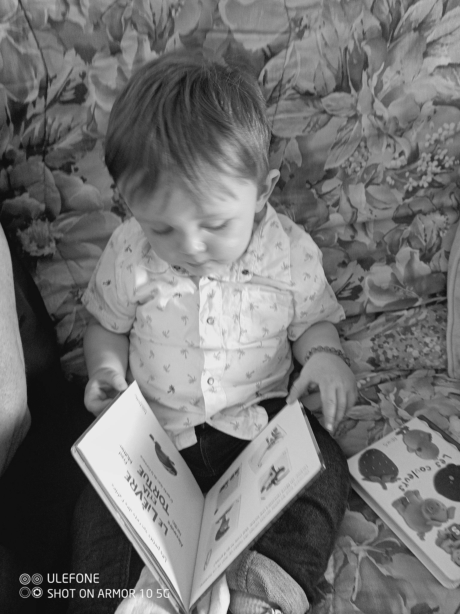Hayden participe au concours pour gagner de l'argent avec cette photo : adaptation, arm, baby, black, black_and_white, book, child, comfort, monochrome, monochrome_photography, person, photograph, publication, reading, room, sitting, smile, snapshot, style, toddler