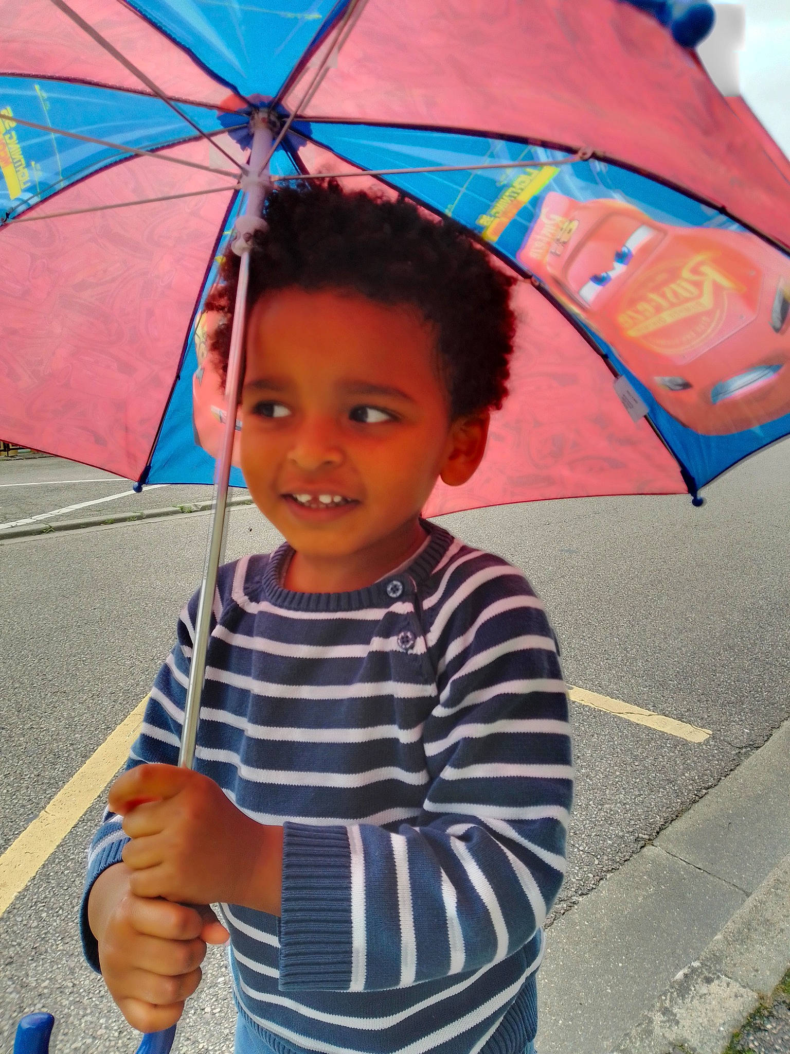 Issa participe au concours pour gagner de l'argent avec cette photo : black, blue, chin, clothing, cool, face, fun, happy, joy, orange, person, photograph, public_space, red, shade, smile, standing, tints_and_shades, toddler, travel