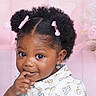 toddler, child, girl, portrait, curly_hair, pink_bows, cute, smiling, finger_on_mouth, floral_background, white_shirt, indoor, closeup, adorable, young_child, african_american, happy, funny_expression, baby, person