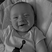 Jaxson is registered to the contest to win money with this photo: baby, smiling, infant, tshirt, sitting, portrait, face, clothing, seat, cushion, child, happy, monochrome, young, person, indoor, cute, relaxed, babywear, infantwear