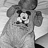baby, newborn, sleeping, onesie, cartoon, bed, blanket, resting, infant, cute, monochrome, clothing, peaceful, child, portrait, cozy, soft, small, lying_down, indoor