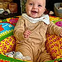 baby, child, smiling, onesie, colorful, play_ring, indoor, cute, happy, face, person, cozy, decor, basket, toy, clothing, infant, home, sitting, portrait