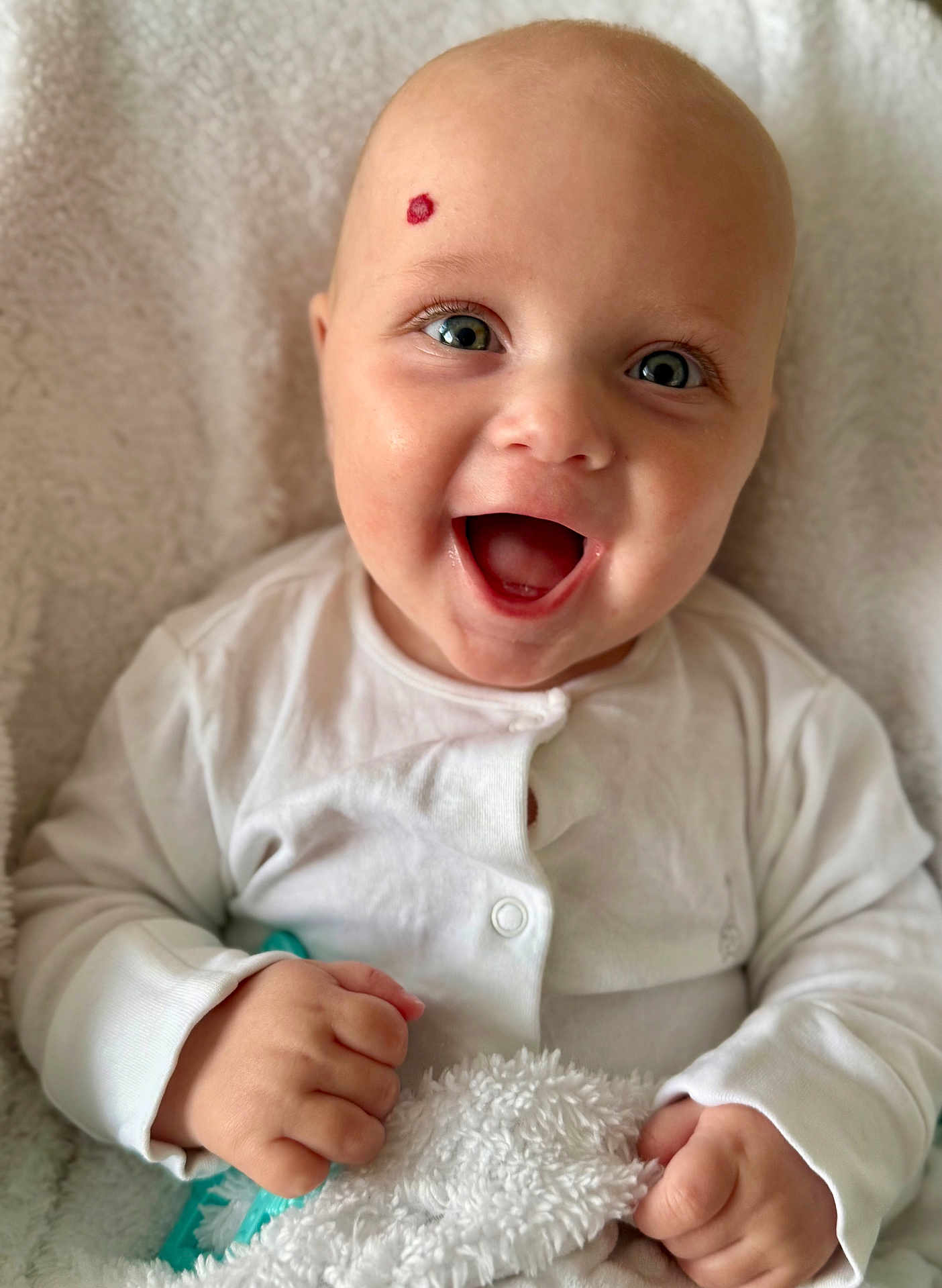 George is registered to the contest to win money with this photo: baby, smiling, happy, infant, face, eyes, hand, white_clothing, blanket, texture, soft, cozy, portrait, closeup, cute, child, indoor, skin, head, newborn