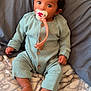 baby, bed, blanket, bodypart, clothing, couch, cushion, cutlery, face, finger, furniture, hand, head, homedecor, pants, person, photography, portrait, sitting, spoon