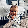 toddler, child, baby, striped_clothing, knitwear, pigtails, blanket, carpet, living_room, couch, throw_blanket, curious_expression, sitting, indoor, soft_lighting, person, cute, playful, home, portrait