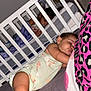 baby, crib, blanket, sleeping, pacifier, bed, pillow, toddler, room, toy, furniture, child, sleep, infant, bedding, person, nursery, pink, purple, clothing