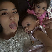Thalia a rejoint le concours — aidez-le/la à gagner de superbes lots ! woman, baby, child, tongue_out, selfie, family, cute, indoor, pink_clothing, white_lace, patterned_pillow, face, head, skin, expression, holding, portrait, sitting, relaxed, playful