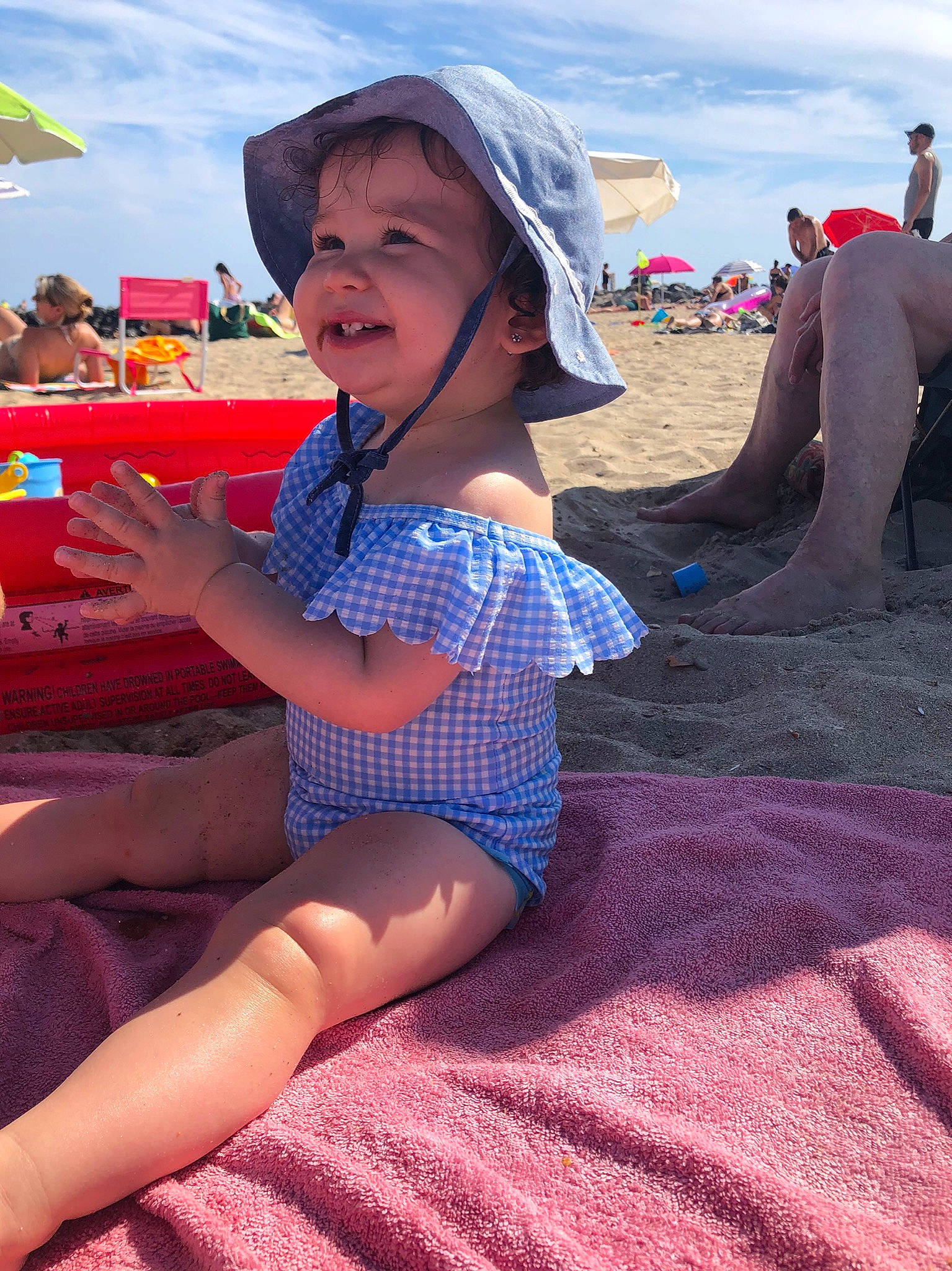 Aïna participe au concours pour gagner de l'argent avec cette photo : beach, cloud, face, fun, hat, human_leg, knee, leisure, magenta, people_on_beach, person, pink, recreation, sand, shorts, sky, summer, sun_hat, thigh, toddler