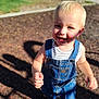 toddler, child, smiling, blonde_hair, blue_eyes, denim_overalls, striped_shirt, outdoor, sunny, playground, walking, happy, cute, person, feet, shadow, daylight, casual_clothing, young_child, portrait