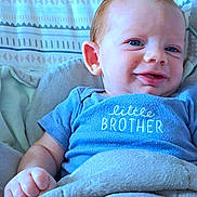 Ryder is registered to the contest to win money with this photo: baby, child, smile, blue_onesie, blanket, face, infant, cute, happy, young, person, portrait, skin, hand, head, eyeball, indoors, fabric, clothing, resting