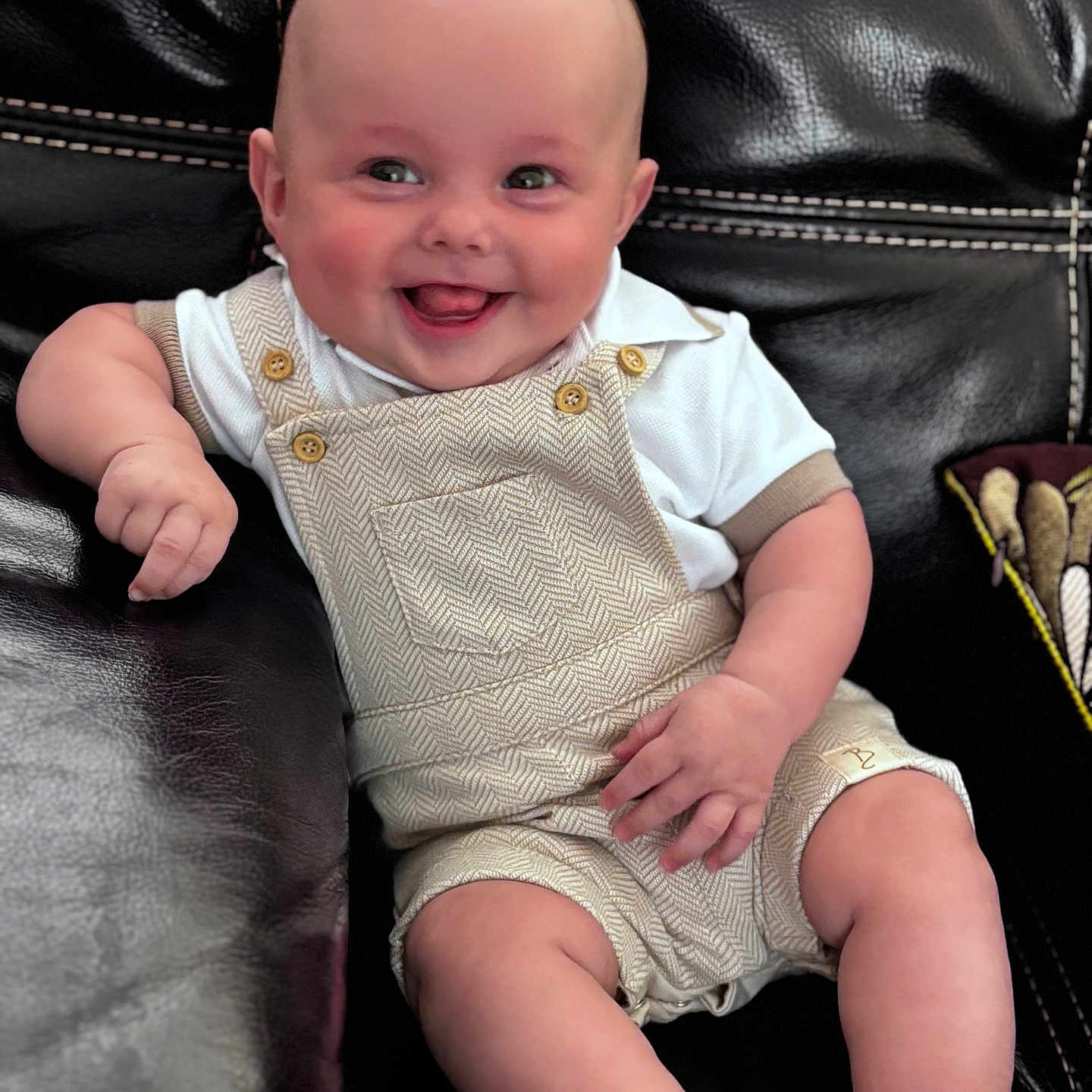 Tobias joined the competition — help win amazing prizes! baby, child, clothing, comfort, couch, cute, expression, face, happy, head, indoors, infant, leather, overalls, person, portrait, relaxing, sitting, skin, smiling