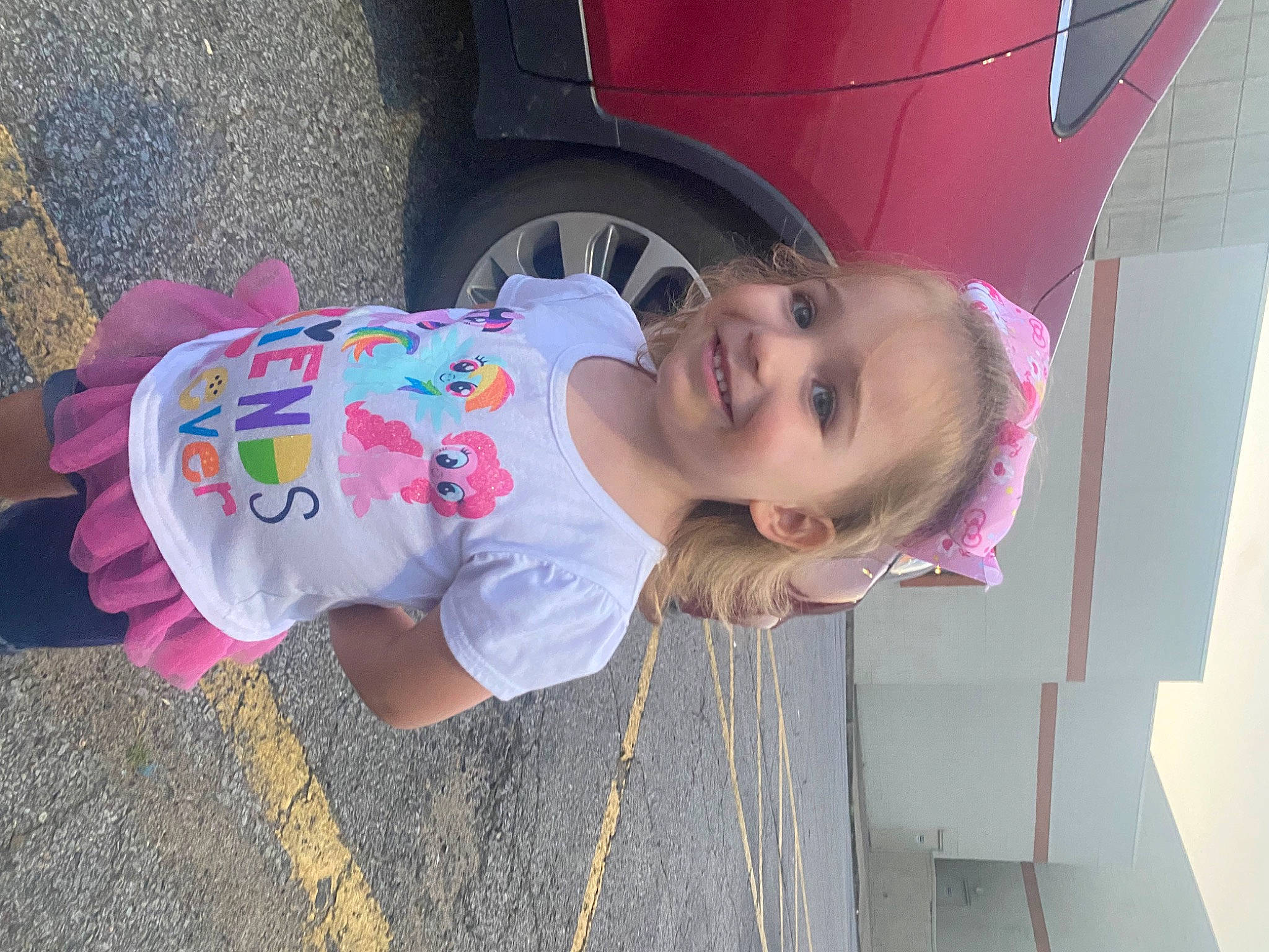 Lyra is registered to the contest to win money with this photo: automotive_tire, automotive_wheel_system, baby, baby_toddler_clothing, car, child, face, fender, fun, hat, joy, magenta, mouth, person, pink, skin, smile, tire, toddler, vehicle
