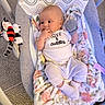 baby, infant, baby_rocker, blanket, mitt, plush_toy, carpet, clothing, cute, comfort, infant_clothing, soft_toys, baby_boy, indoor, person, portrait, relaxing, baby_accessory, baby_bedding, smiling