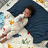 Wave is registered to the contest to win money with this photo: baby, bedroom, bottle, child, colorful, comfort, curly_hair, cute, dinosaur_pattern, indoors, infant, lying_down, mattress, milk, pillow, playful, resting, sleepwear, soft_toys, young_child