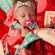 Katherine is registered to the contest to win money with this photo: baby, blanket, child, colorful, comfort, cozy, cute, face, hand, headband, indoors, infant, pacifier, patterned_blanket, peaceful, portrait, resting, sleeping, soft, young_child