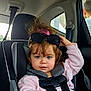 child, toddler, car_seat, seatbelt, sunglasses, pink_sweater, hair_bow, curly_hair, blue_eyes, buckle, hand, car_interior, window, backseat, portrait, candid, baby, headrest, clothing, passenger