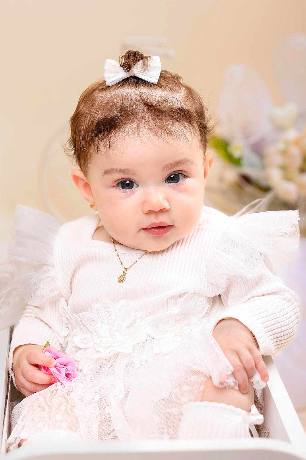 Kalyna is registered to the contest to win money with this photo: baby, child, infant, white_dress, bow, flower, portrait, cute, tulle, lace, jewelry, necklace, earrings, soft_lighting, indoor, close_up, curious, sitting, pink_flower, adorable