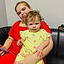 black_leather, casual, child, comfort, couch, curious, dress, face, family, hand, hearts_pattern, holding, indoor, love, person, red_dress, sitting, toddler, woman, yellow_dress