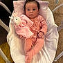 Holly is registered to the contest to win money with this photo: baby, infant, pink_onesie, plush_toy, blanket, baby_rocker, carpet, cushion, indoor, child, soft_toy, cute, cozy, person, portrait, relaxing, furniture, baby_clothing, expression, comfort