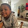 Amari joined the competition — help win amazing prizes! child, toddler, smiling, hoodie, living_room, carpet, foot, person, furniture, plant, vase, television, window, door, home_decor, floor, indoor, happy, portrait, casual