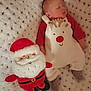 baby, sleeping, reindeer_outfit, plush_toy, santa_claus, blanket, cozy, holiday, christmas, infant, cute, soft, red_clothing, white, smiling_toy, indoor, child, festive, warm, toy