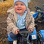 Robbie joined the competition — help win amazing prizes! blue, blue_hat, boots, child, clothing, cute, dirt, farm, happy, hay_bales, jacket, outdoor, person, play, pom_poms, smiling, steering_wheel, toddler, toy_tractor, vehicle