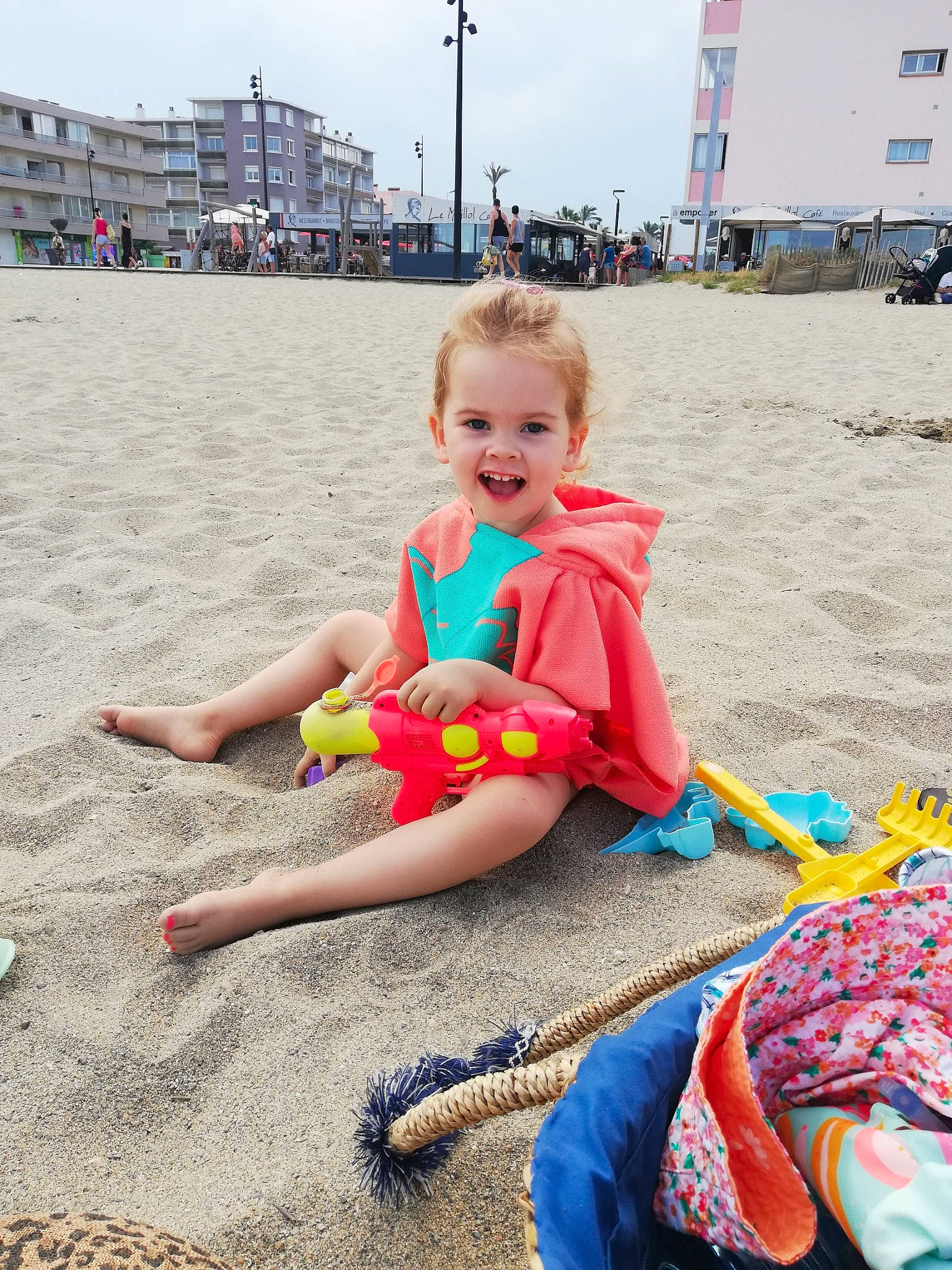 Angela participe au concours pour gagner de l'argent avec cette photo : beach, body_of_water, child, event, fun, happy, hat, human_leg, joy, leisure, magenta, person, recreation, sand, shorts, sitting, sky, smile, t_shirt, toddler