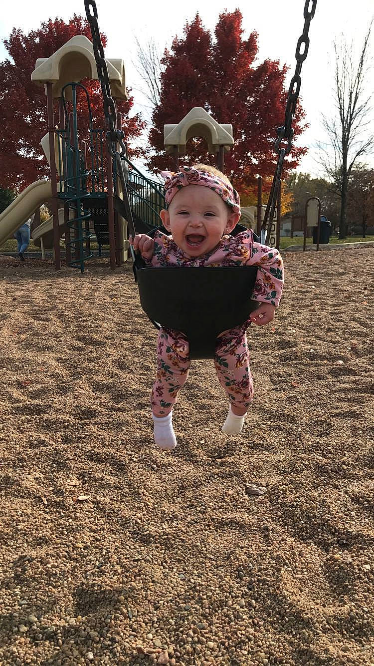 Talia joined the competition — help win amazing prizes! baby, baby_toddler_clothing, child, city, fun, grass, happy, headwear, leaf, leisure, outdoor_play_equipment, people_in_nature, person, plant, playground, recreation, sky, smile, swing, toddler