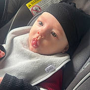 Cooper joined the competition — help win amazing prizes! baby, child, car_seat, beanie, bib, clothing, seatbelt, infant, face, expression, light, soft_light, indoors, cute, portrait, person, warm_clothing, bundle, seat, young