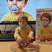 Ethan a rejoint le concours — aidez-le/la à gagner de superbes lots ! figurine, toddler, pacifier, toy_cars, computer_screen, portrait, product_box, realistic_art, child_figure, yellow_shirt, plastic_stand, desktop_keyboard, table_surface, blue_eyes, brown_hair, digital_art, collectible, miniature, indoor, photography