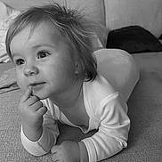 Arlo is registered to the contest to win money with this photo: baby, toddler, child, face, hand, couch, indoor, long_sleeve, curly_hair, black_and_white, portrait, expression, thinking, close_up, soft_light, cozy, eyes, furniture, person, laying