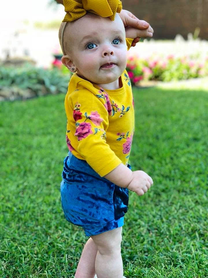 Kynslee is registered to the contest to win money with this photo: baby, baby_toddler_clothing, child, dress, fawn, flower, grass, meadow, outerwear, pattern, person, plant, play, spring, toddler, yellow