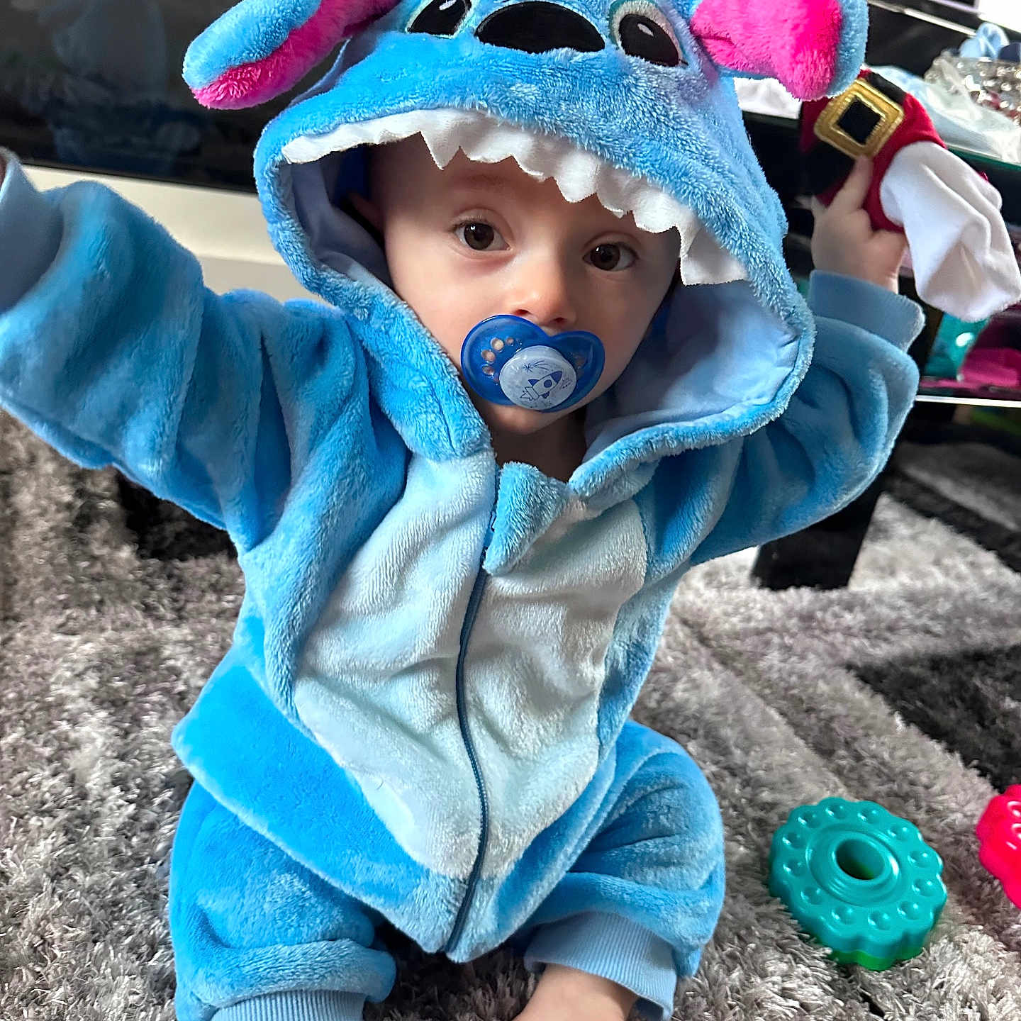 Tommy joined the competition — help win amazing prizes! baby, blue_costume, carpet, child, curious, cute, eyes, face, foot, hand, home, hoodie, indoor, pacifier, play, plush, sitting, soft, toddler, toy