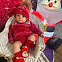 Tommy is registered to the contest to win money with this photo: toddler, child, red_clothing, knit_hat, santa_slippers, wicker_chair, inflatable_santa, holiday_decor, festive, indoors, carpet, flooring, cute, warm_lighting, portrait, christmas, cozy, smiling, baby, seasonal