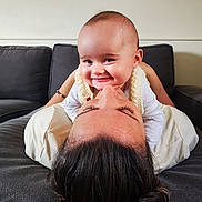 Giulia participe au concours pour gagner de l'argent avec cette photo : baby, adult, smile, face, couch, indoor, person, happy, child, family, love, affection, closeup, head, skin, hair, casual, relaxation, bonding, cozy