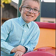 Ugo participe au concours pour gagner de l'argent avec cette photo : background_blur, boy, casual_clothing, child, daylight, face, fun, glasses, hands, happy, leisure, light_blue_shirt, outdoor, park, person, playground, recreation, short_hair, smile, youth
