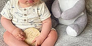 Clovis a rejoint le concours — aidez-le/la à gagner de superbes lots ! baby, child, plush_toy, koala, blanket, soft_texture, wooden_plaque, sitting, indoors, cute, infant, clothing, portrait, toy, comfortable, young, expression, hands, feet, floor