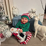 Malone participe au concours pour gagner de l'argent avec cette photo : baby, child, elf_costume, christmas, holiday, plush_toys, santa_doll, reindeer, owl, polar_bear, festive, christmas_tree, decorations, striped_pants, green_hat, indoor, smiling, cute, floor, holiday_spirit