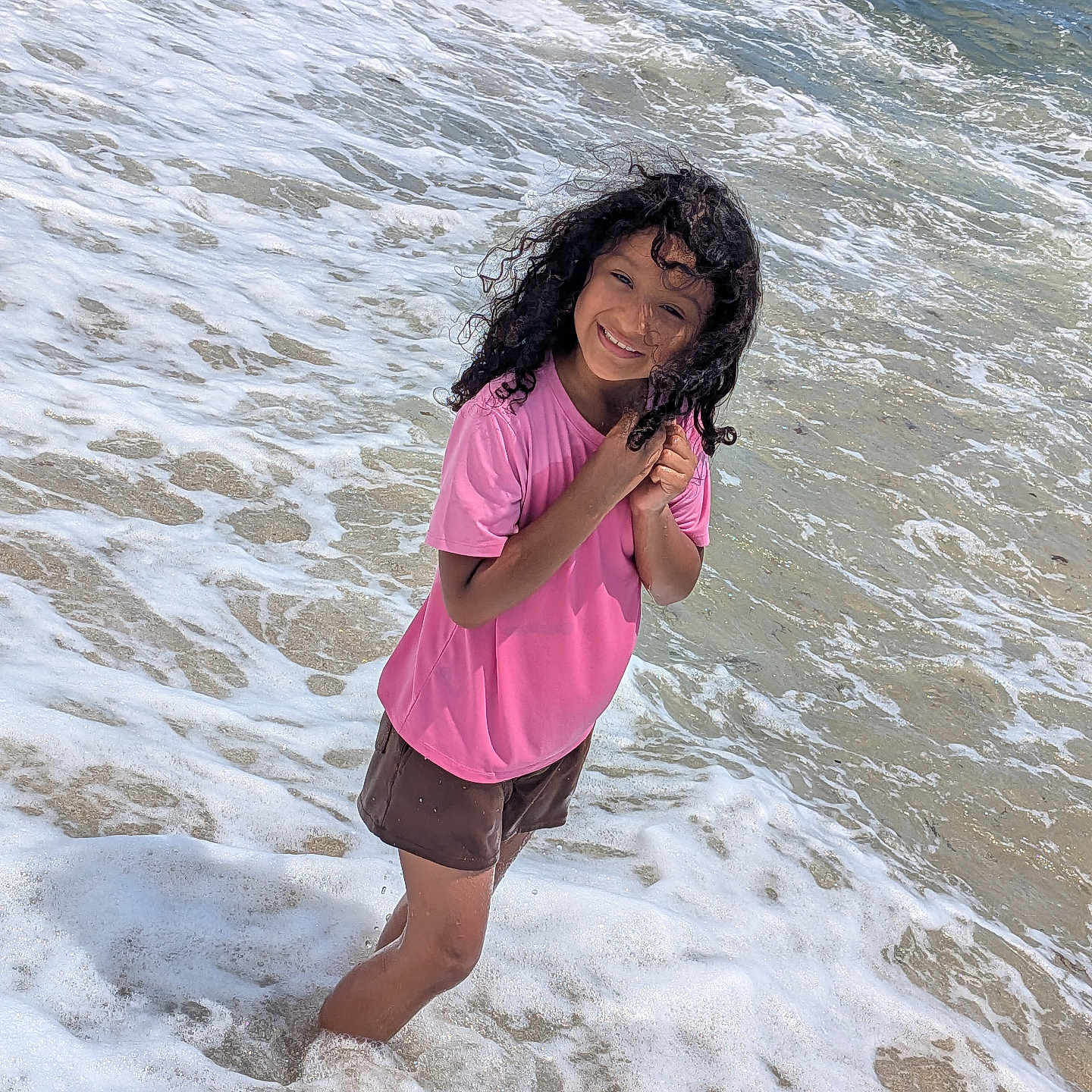 Kimberlee Montero joined the competition — help win amazing prizes! child, smiling, beach, ocean, seawater, waves, surf, foam, shoreline, outdoors, summer, pink_shirt, shorts, curly_hair, wet_hair, standing, portrait, happy, sunlight, vacation