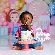 Reign joined the competition — help win amazing prizes! baby, cake, birthday, party, balloons, decorations, child, smiling, pink, blue, pastel_colors, overalls, floor, celebration, colorful, cute, frosting, happy, sitting, one_year_old