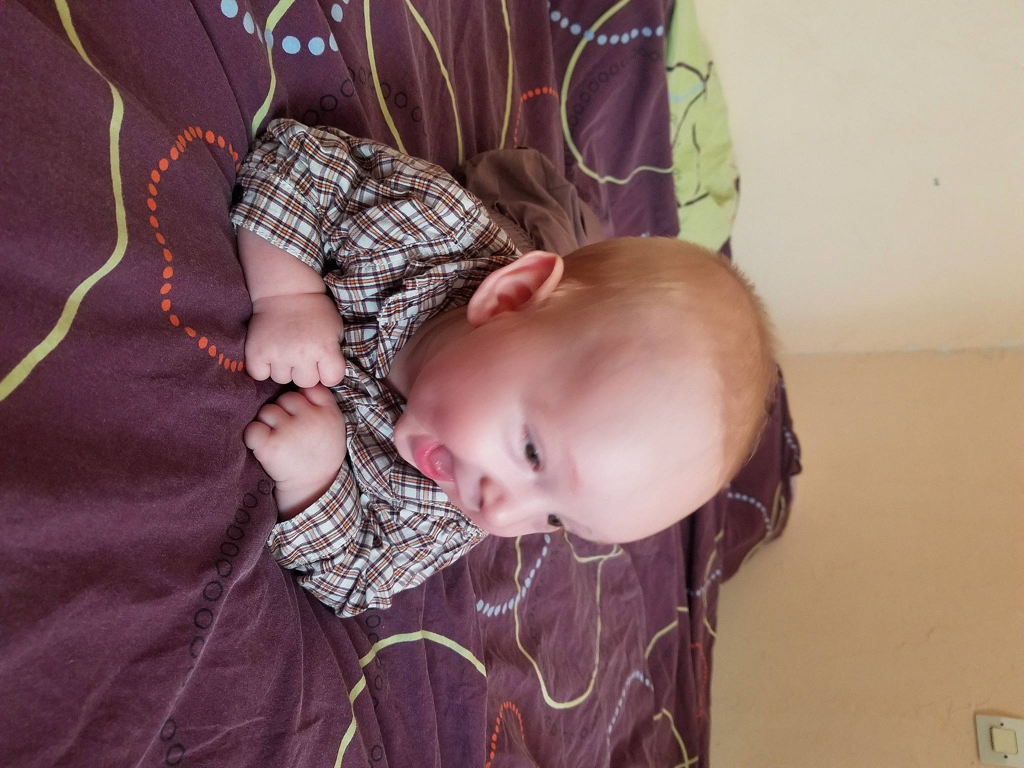 Gabriel participe au concours pour gagner de l'argent avec cette photo : arm, baby, baby_products, baby_toddler_clothing, cheek, comfort, eyelash, fashion_accessory, finger, hand, happy, headgear, iris, neck, pattern, person, purple, room, sleeve, toddler