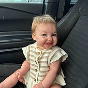 Sutton is registered to the contest to win money with this photo: baby, child, car_seat, blue_eyes, smile, striped_clothing, knitwear, food, fries, seatbelt, car_interior, window, door, cute, happy, messy, sitting, person, infant, portrait