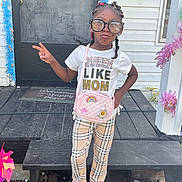 Deshawna joined the competition — help win amazing prizes! child, girl, glasses, plaid_pants, pink_purse, tshirt, porch, door, welcome_mat, wooden_steps, decorations, peace_sign, casual_clothing, outdoor, smile, fashion, standing, accessories, hairstyle, confident