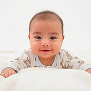 Adriel is registered to the contest to win money with this photo: baby, smiling, infant, blanket, onesie, animal_print, cute, happy, face, child, portrait, indoor, soft_light, young, hands, lying_down, head, skin, expression, toddler