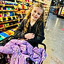 Graci joined the competition — help win amazing prizes! aisle, blonde_hair, bright_lighting, casual, cheese, child, clothing, curly_hair, food, girl, grocery_store, happy, indoor, person, purple_jacket, retail, shopping, shopping_cart, smiling, store_shelves