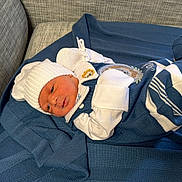 Noah joined the competition — help win amazing prizes! baby, newborn, infant, child, portrait, lying_down, blanket, blue, hat, mittens, sweater, clothing, couch, indoors, cozy, sleeping, face, eyes, photography, home
