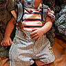 Noah is registered to the contest to win money with this photo: baby, infant, sleeping, pacifier, portrait, striped_clothing, suspenders, shorts, socks, blanket, plush_blanket, bed, lying_down, peaceful, indoors, close_up, face, newborn, textile, cozy